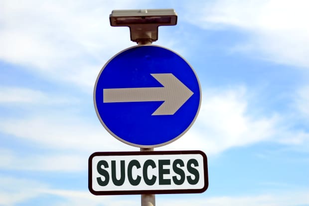 Blue sign with arrow pointing right, directing traffic one way