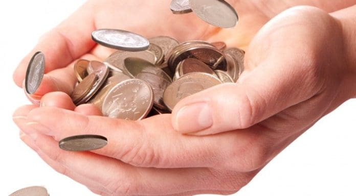 Coins in hands representing freelancer paid by the hour.