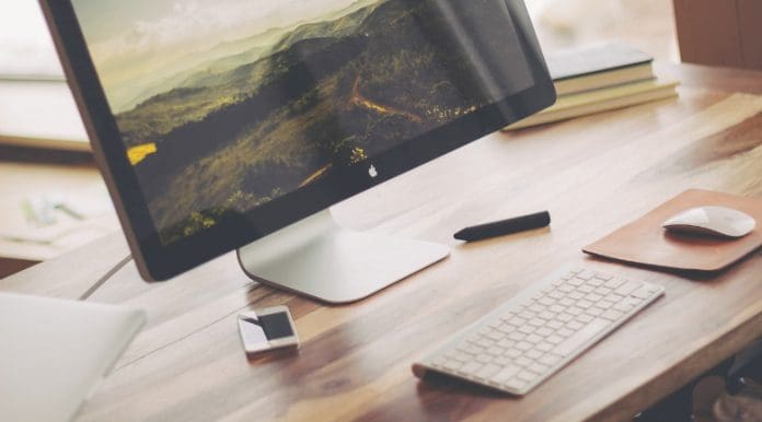 A desktop and laptop on a desk, multitasking in a startup environment.