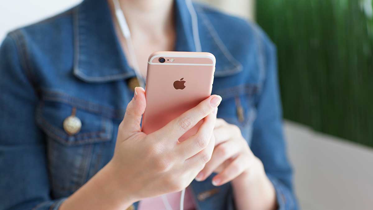 apple iphone Woman looking at Apple iPhone representing new iOS 15 beta that will blur nude photos.