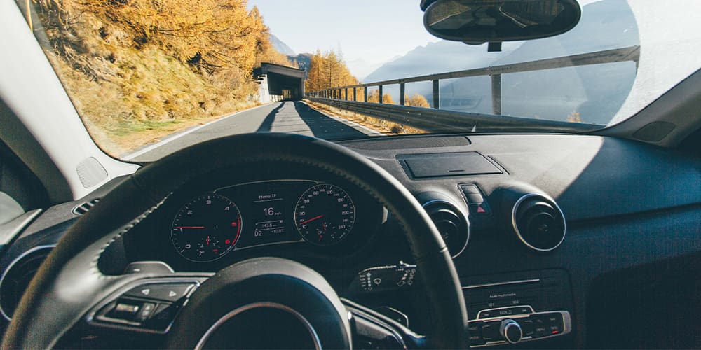 Driverless car dashboard facing mountain road.