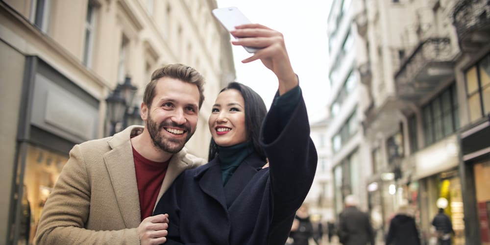 Couple taking video with mobile phone, prepared for e-commerce.