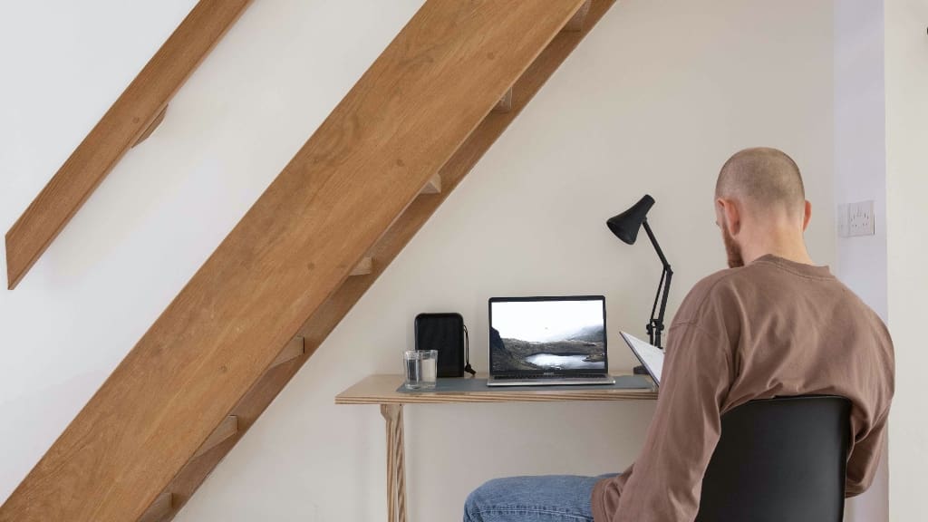 Man sitting at desk representing working smarter not harder.