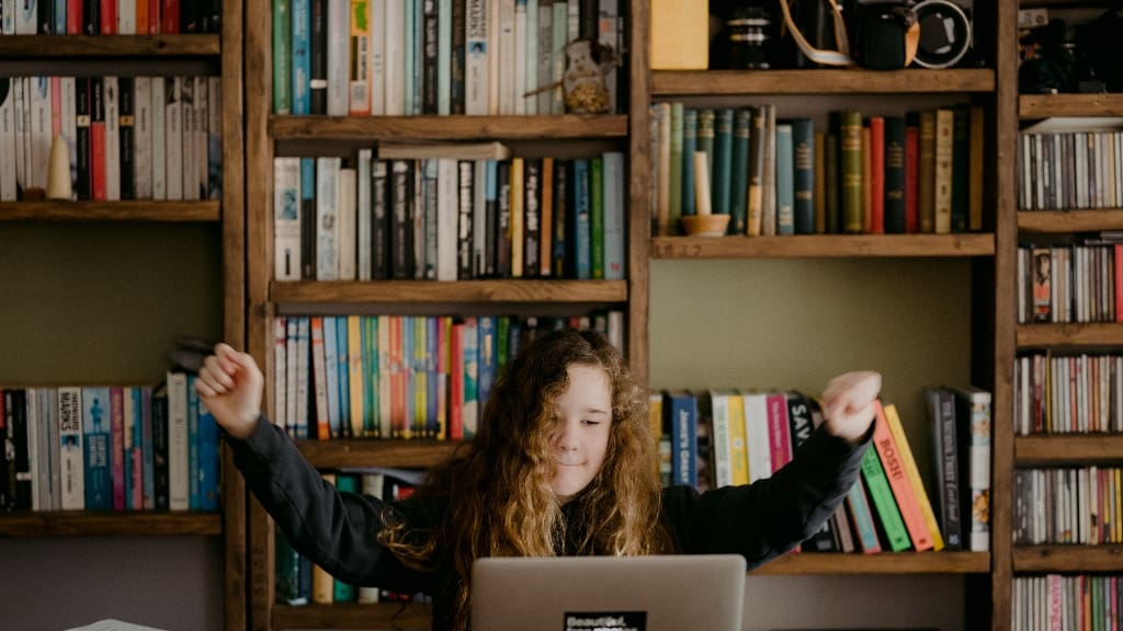 Person with books and computer representing research Person with books and computer representing research