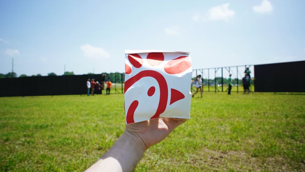 Person holding Chick-Fil-A sandwich bag representing 3-day workweek trial Person holding Chick-Fil-A sandwich bag representing 3-day workweek trial