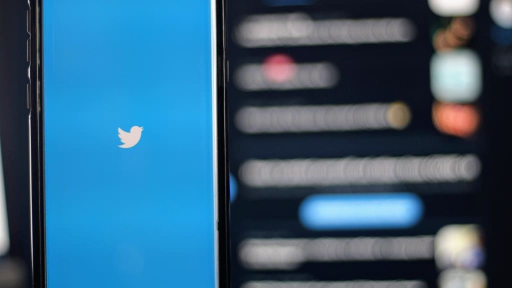Twitter on phone with tweets blurred in the background twitter api
