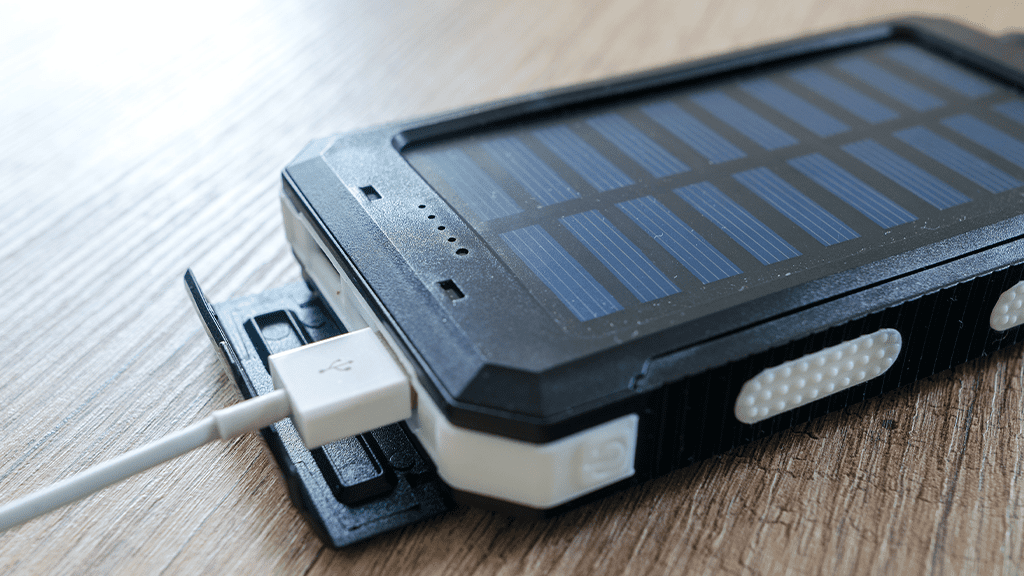 LithiumBatteryDevice A charging device with solar panels, powered by lithium batteries, sits plugged in on a table.