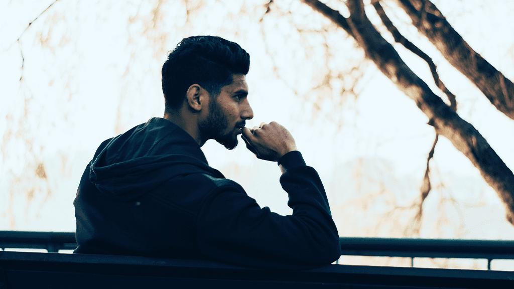 A man sitting on a park bench thinking about various life advice.