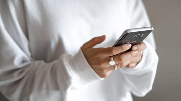 Person holding phone representing AI content