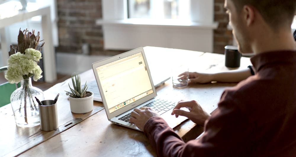 Man working on laptop representing vanity metrics in real estate.