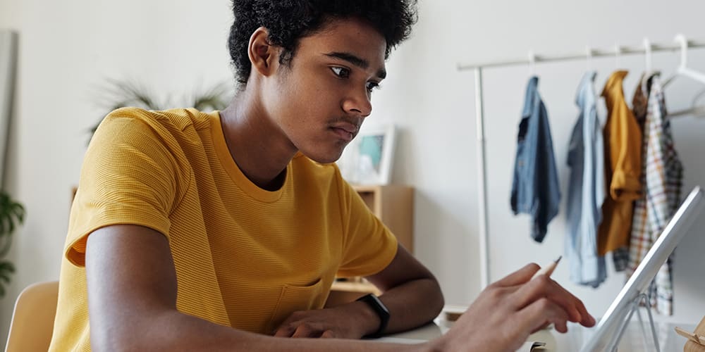 Student viewing internet on tablet.