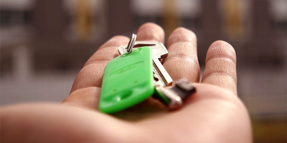 Hand holding keys to homeownership.