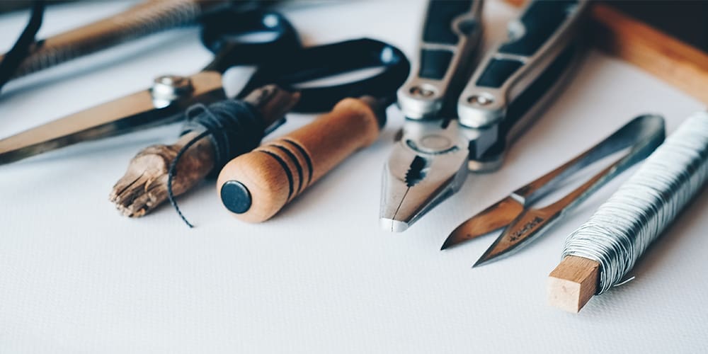 Crafting tools on a piece of white parchment paper, tools of the maker scene.