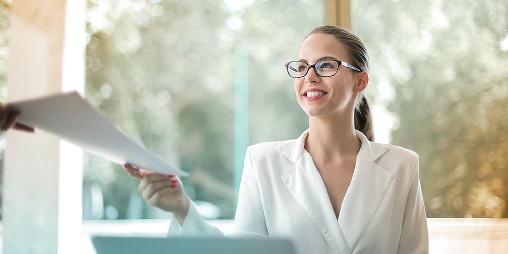 Smiling rockstar employee accepting paper from off screen.