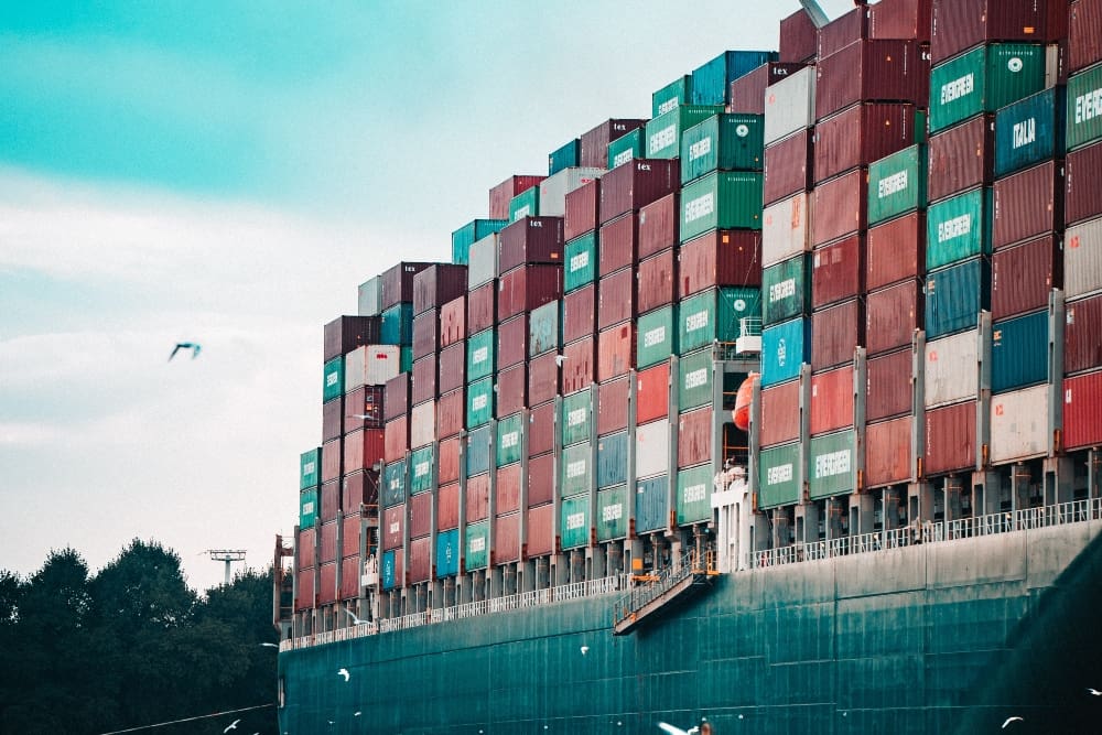 Large cargo ship with many multi-colored bins representing the supply chain. 