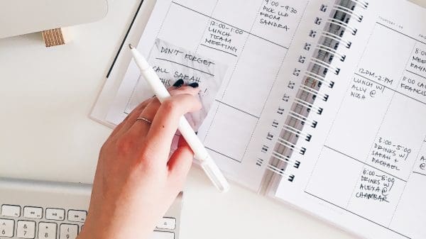 Person writing in calendar representing goals and habits