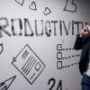 productivity written on wall with man on cellphone.