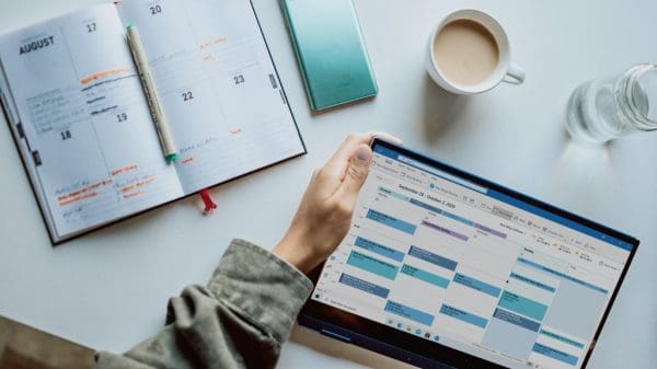 Person using digital and written calendar for productivity during free time.