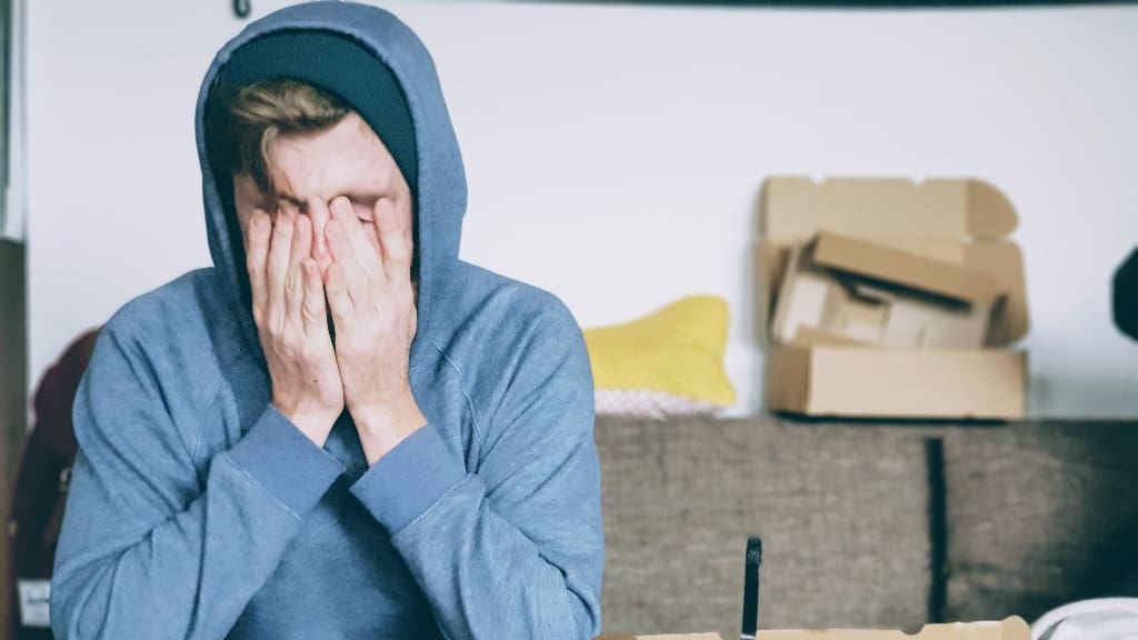 person with face in hands representing young adults living with parents