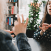 A woman practices ASL (American sign language) with another person, speaking to emphasize what they're saying.