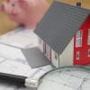 magnifying glass, piggy bank, and credit paperwork representing home buying