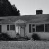 older home in black and white representing small town america being ruined by Airbnb