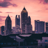 A sunset view of the Atlanta downtown skyline, with housing options in the distance among the pink and purple sky.