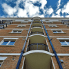 A set of affordable housing apartment buildings, looking up from the ground toward the sky.